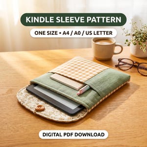 Puede incluir: Una funda de tela para lector electrónico con exterior verde salvia, bolsillo de cuadros vichy beige y blanco, y solapa floral con botón de madera. La funda contiene un lector, una libreta y un bolígrafo. Texto: KINDLE SLEEVE PATTERN, ONE SIZE A4 / A0 / US LETTER, DIGITAL PDF DOWNLOAD.