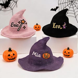 May include: Three pointed witch hats in pink, black, and purple. The pink hat features the name Eric and a star wand. The black hat displays the name Leo and a witch graphic. The purple hat shows the name Mia and a jack-o'-lantern pumpkin graphic.