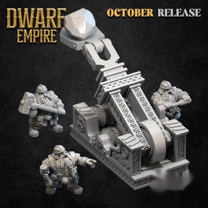 May include: A light grey miniature catapult with a stone projectile, featuring intricate geometric patterns on its frame. Two small dwarf figurines are included, one holding a large hammer and the other pointing forward. Text reads DWARF EMPIRE OCTOBER RELEASE.
