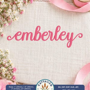Pode incluir: A palavra emberley está bordada numa fonte cursiva rosa brilhante sobre um tecido texturizado branco sujo. Um logótipo circular apresenta o texto Cattails & Swashes com uma ilustração de taboas. O texto lista os tamanhos 25mm, 38mm, 51mm, 64mm, 77mm.