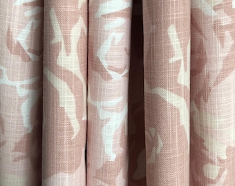 May include: A curtain fabric featuring a large-scale floral pattern in shades of dusty rose and cream. The textile has a visible woven texture with a grid-like weave pattern, creating vertical folds that highlight the repeating rose motif across the surface.