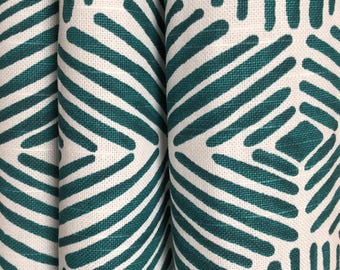 Puede incluir: Una tela textil con un patrón geométrico repetitivo de líneas de color verde azulado oscuro sobre un fondo blanco roto. El diseño consiste en trazos paralelos y angulados que forman figuras de diamantes y cuadrados en la superficie tejida.