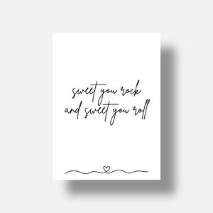 May include: A white rectangular print featuring the black handwritten text "sweet you rock and sweet you roll" centered in the middle. Below the text, a thin black horizontal wavy line is drawn with a small heart shape in the center.