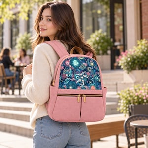 Può includere: Uno zaino rosa polvere con un pannello frontale caratterizzato da un vivace motivo sottomarino blu scuro con tartarughe marine, coralli e piante acquatiche. La borsa include un manico, spallacci regolabili e una tasca frontale con cerniere dorate.