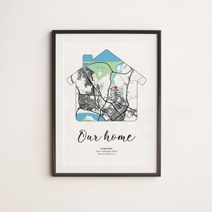Op de afbeelding: Een ingelijste wandprint met een kaart van Bergen, Noorwegen, in de vorm van een huisomtrek. De kaart bevat zwarte straten, groene parkgebieden en blauwe wateren. Het toont de tekst Our home, The Miller Family en geografische coördinaten.