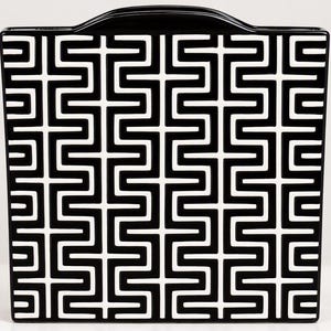 May include: A square ceramic vase featuring a glossy black finish with a repeating white geometric maze pattern. The vase has a flat base and a curved handle integrated into the top edge, creating a symmetrical and structured appearance.