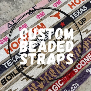 May include: A collection of custom beaded straps featuring various colours, patterns, and text including Greek letters, university names, and sports themes. Each strap is crafted with small beads arranged to display specific designs and lettering.
