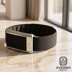 May include: A black woven fabric wristband featuring a polished silver-tone metal rectangular clasp with a small engraved logo. The interior of the band has a series of oval-shaped textured pads. The logo AVENRO WRIST is visible in the corner.