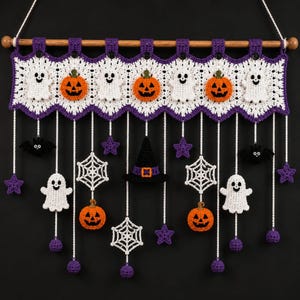 May include: A Halloween-themed crochet wall hanging featuring a white and purple scalloped banner with alternating white ghosts and orange jack-o'-lanterns. Dangling from the banner are crocheted bats, spiders, stars, and a witch hat.
