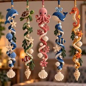 May include: Five vertical hanging decorations featuring crocheted marine life including a blue dolphin, green turtle, pink octopus, blue whale, and orange seahorse, accented with crocheted starfish, seashells, coral, and wooden beads on strings.