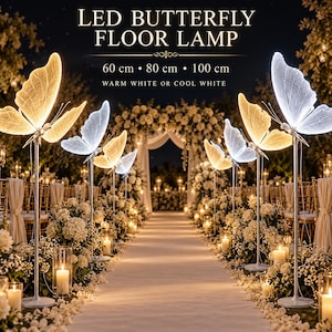 May include: LED butterfly floor lamp with text reading LED BUTTERFLY FLOOR LAMP, 60 cm, 80 cm, 100 cm, and WARM WHITE OR COOL WHITE. The lamp features illuminated butterfly-shaped shades in warm yellow and cool white light on thin metal stands.
