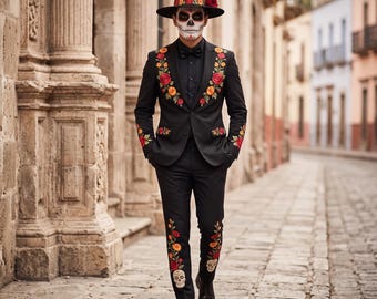 Può includere: Un abito nero con vivaci ricami floreali in rosso, arancione e giallo, abbinato a un cappello nero coordinato con una fascia floreale. La giacca e i pantaloni presentano intricati motivi a rose e teschi in un design molto colorato.