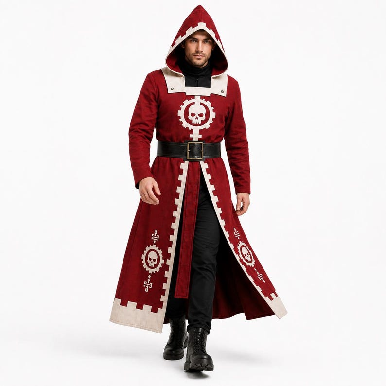 Pu&ograve; includere: Un lungo cappotto con cappuccio rosso scuro, caratterizzato da bordi bianchi e un emblema bianco a forma di ingranaggio con un teschio al centro sul petto e sui pannelli inferiori. Il cappotto include una cintura nera con fibbia rettangolare.