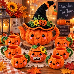 May include: A crochet tea set featuring a large pumpkin-shaped teapot wearing a black witch hat with a small pumpkin topper, accompanied by five matching pumpkin-shaped cups and a lidded sugar bowl with the word SUGAR stitched on the front.