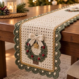 May include: A cream-colored crocheted table runner featuring a scalloped green border with small white accents. The runner is decorated with a central crocheted wreath motif in green, accented with red berries, a gold star, and a cream-colored bow.