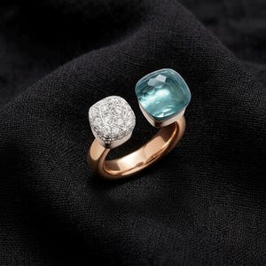 Könnte beinhalten: Ein offener Ring mit einer polierten Roségold-Schiene. Ein Ende des Rings ist mit einem quadratischen, facettierten hellblauen Edelstein besetzt, während das andere Ende eine quadratische Fassung mit zahlreichen kleinen, funkelnden weißen Diamanten aufweist.