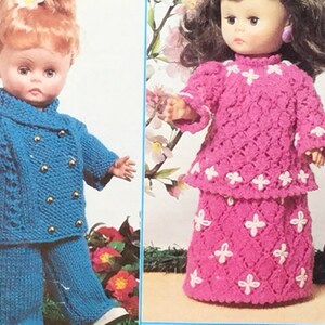 Pode incluir: Duas bonecas vestindo roupas de tricô. A boneca à esquerda está vestindo uma jaqueta e calças de tricô azul. A boneca à direita está vestindo um vestido e uma saia de tricô rosa.