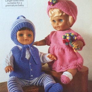 May include: Two knitted doll outfits. One outfit is blue and white striped with a blue waistcoat and matching hat. The other outfit is pink with a pink hat and a bouquet of flowers.