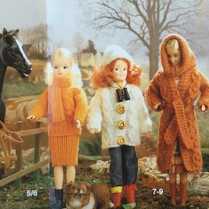 May include: Three dolls wearing knitted sweaters and coats. The doll on the left is wearing an orange sweater and skirt. The doll in the middle is wearing a white cable knit sweater and jeans. The doll on the right is wearing a brown hooded coat. The dolls are standing in a snowy forest setting. 5/6 and 7-9 are written on the bottom of the image.