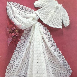 Peut inclure: Un ensemble de couverture et de cardigan pour bébé en crochet blanc. La couverture est ornée d'un motif de dentelle délicat et le cardigan a une fermeture à bouton.