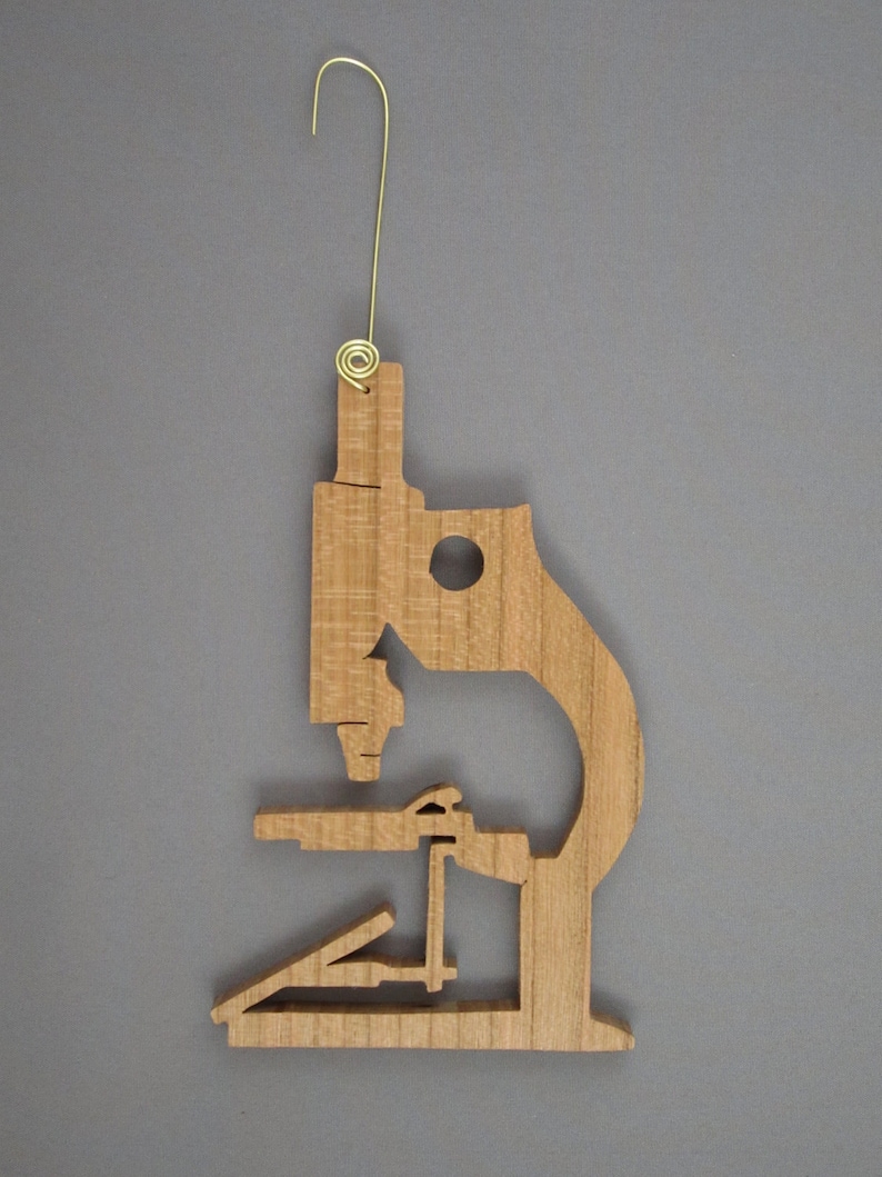 May include: Wooden ornament shaped like a microscope, with a gold wire hanger.