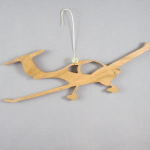 May include: Wooden ornament shaped like a small airplane, with a gold loop for hanging.