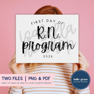 Può includere: Un cartello rettangolare bianco con testo nero che recita FIRST DAY OF R.N. program 2026. Il cartello presenta un design pulito con un carattere in grassetto in stile manoscritto per il testo principale e un semplice carattere sans-serif per l'anno.