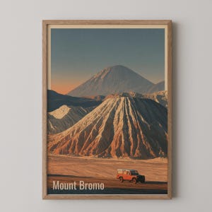 Puede incluir: Una impresión de arte mural vertical enmarcada que representa un paisaje del Monte Bromo con un vehículo todoterreno rojo en primer plano. La escena muestra montañas volcánicas superpuestas bajo un cielo suave, con el texto Mount Bromo abajo.