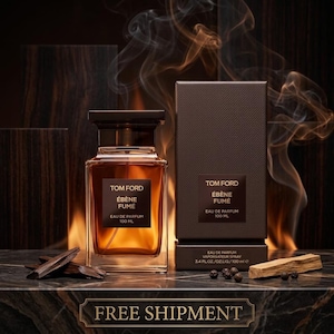 May include: A Tom Ford Ébène Fumé eau de parfum 100 ml glass bottle and its matching dark brown textured box. The bottle contains amber liquid and features a black label with white text. Dark wood pieces and small peppercorns sit nearby.
