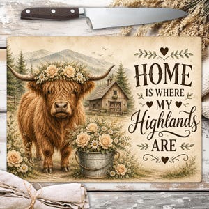 Può includere: Un tagliere rettangolare con una mucca Highland marrone che indossa una corona di fiori, un fienile rustico e un secchio di metallo pieno di fiori. Il testo recita "HOME IS WHERE MY Highlands ARE" con decorazioni a forma di cuore.