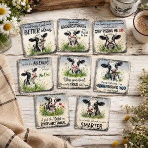 Könnte beinhalten: Ein Set aus acht quadratischen Untersetzern mit Illustrationen von Kühen auf Grasflächen und humorvollen Texten. Jeder Untersetzer zeigt eine individuelle Kuh und Sprüche wie I'm not bossy, Go ahead, UNDERESTIMATE me und I put the FUN in DYSFUNCTIONAL.