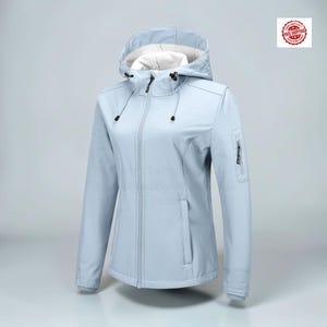 May include: A light blue softshell jacket featuring a hood with white lining, a full-length front zipper, and adjustable drawstrings. The jacket includes a zippered pocket on the left sleeve and two vertical zippered pockets on the front torso.
