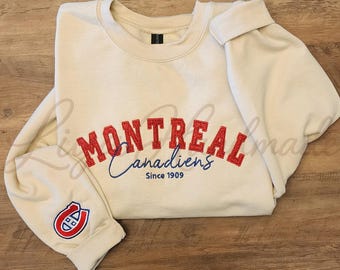 Può includere: Una felpa girocollo color crema con la scritta ricamata in rosso MONTREAL, accompagnata dal testo in blu Canadiens in corsivo e dal testo in blu Since 1909 sottostante. Un logo rosso, bianco e blu è ricamato sul polsino della manica sinistra.