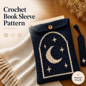 May include: A dark blue crochet book sleeve featuring a cream-colored crescent moon and star design within an arched frame. The sleeve has a single wooden button closure and is accompanied by a matching dark blue crochet bookmark.