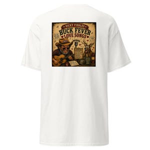 May include: A white t-shirt featuring a graphic print on the back. The design shows a cartoon man in a cowboy hat playing an acoustic guitar next to a deer, with the text "DICKY FIDDLES BUCK FEVER LOVE SONGS" and a list of song titles.