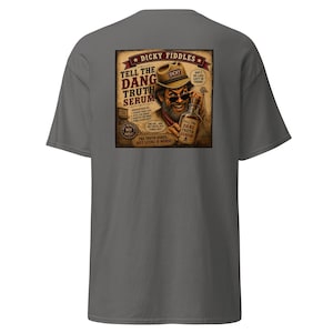 May include: A charcoal gray t-shirt featuring a graphic on the back. The design depicts a bearded person wearing a hat and sunglasses, holding a bottle labeled "Tell The Dang Truth Serum." The text includes "Dicky Fiddles" and "The Truth Hurts... But Lying Is Worse!"