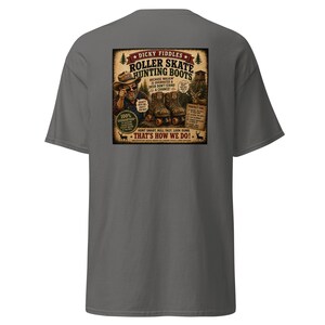 May include: A charcoal gray t-shirt featuring a graphic on the back. The design depicts a person in a hat and sunglasses with roller skate hunting boots, accompanied by text including "Dicky Fiddles Roller Skate Hunting Boots" and "That's How We Do!"