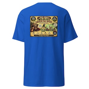 May include: A bright blue short-sleeve t-shirt featuring a rectangular graphic on the back. The graphic depicts a man in a hat, a deer, and a raccoon with the text "Dicky Fiddles Wildlife Brain Fog Spray" and various humorous product claims.
