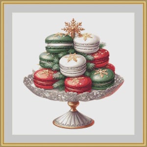 Op de afbeelding: Een feestelijke opstelling van macarons in de vorm van een kerstboom. De macarons zijn rood, wit en groen, versierd met gouden accenten en gerangschikt op een decoratieve zilveren taartstandaard. Een gouden sneeuwvlok bekroont de boom.