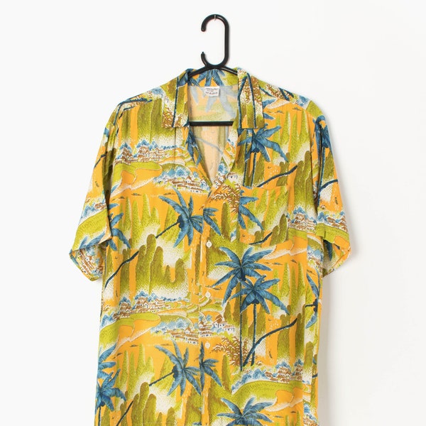 80er Jahre Vintage Hawaiihemd in warmen Gelb mit auffälligen blauen Palmen grünen Bergen und Dorf Motiv - Medium / Large