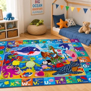 May include: A rectangular area rug featuring a vibrant underwater scene with various sea creatures and an alphabet border. The design includes colorful illustrations of marine life, geometric shapes, and letters from A to Z with corresponding labels.