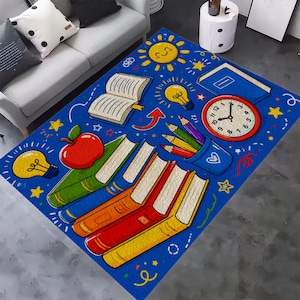 May include: A rectangular area rug with a blue background featuring a school-themed pattern. The design includes a stack of colorful books, a red apple, a clock, light bulbs, a sun, and a pencil holder with colored pencils scattered across the surface.