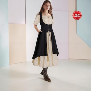May include: A cream-colored dress with short puff sleeves and a tiered skirt, layered under a black sleeveless bodice vest featuring a front lace-up closure with thin black ties. The outfit is paired with dark brown lace-up boots.