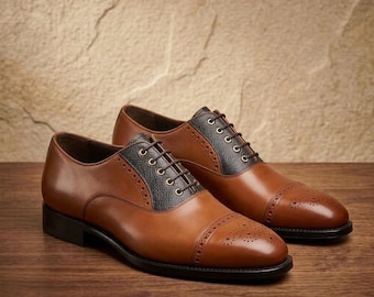 Sapatos Oxford artesanais em couro marrom claro: modelo brogue com biqueira reforçada e painel contrastante.