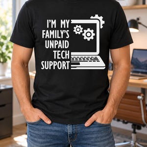 Peut inclure: Un t-shirt noir à manches courtes avec un texte graphique blanc indiquant I'M MY FAMILY'S UNPAID TECH SUPPORT, accompagné d'une illustration au trait blanc d'un ordinateur portable avec deux engrenages sur l'écran et un sur le coin supérieur.