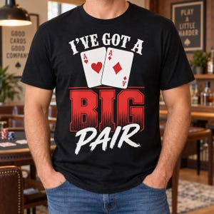 May include: A black short-sleeve t-shirt featuring a graphic print of two playing cards, an ace of hearts and an ace of diamonds, above the red text BIG and the white text PAIR, with the white arched text I'VE GOT A above the cards.