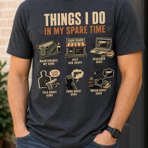 Peut inclure: Un t-shirt gris chiné foncé avec le texte "THINGS I DO IN MY SPARE TIME" au-dessus de six illustrations représentant des activités liées aux armes à feu : entretien, visite de magasins, recherche, discussion, réflexion et rêve.