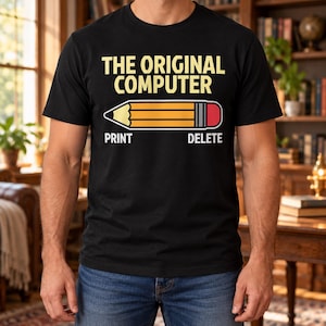 Puede incluir: Una camiseta negra de manga corta con el texto amarillo THE ORIGINAL COMPUTER sobre un gráfico de un lápiz amarillo con goma de borrar rosa. Debajo del lápiz, el texto blanco PRINT está a la izquierda y DELETE a la derecha.