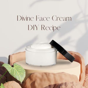 Może przedstawiać: Biały słoik kremu do twarzy z czarną pokrywką, ustawiony na beżowym cokole. Tekst "Divine Face Cream DIY Recipe" jest wyświetlany nad słoikiem. Zielony liść i teksturowane tło dopełniają scenę.