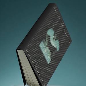 Op de afbeelding: Een hardcover boek getiteld Cracking the Code Third Edition met een zwarte kaft voorzien van een digitaal matrixpatroon van cijfers en een centrale afbeelding van een persoon die op een toetsenbord typt. Het boek staat schuin met witte pagina's.